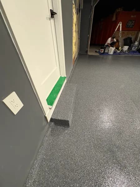 Basalt flake epoxy floor and cove base at a garage doorway in Surrey, BC