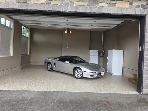 Bean flake epoxy floor in a large garage with a sports car parked inside in Aldergrove, BC