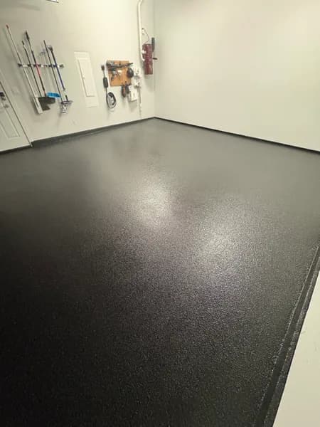 Dark Carbon flake epoxy garage floor with wall-mounted tools in Delta, BC
