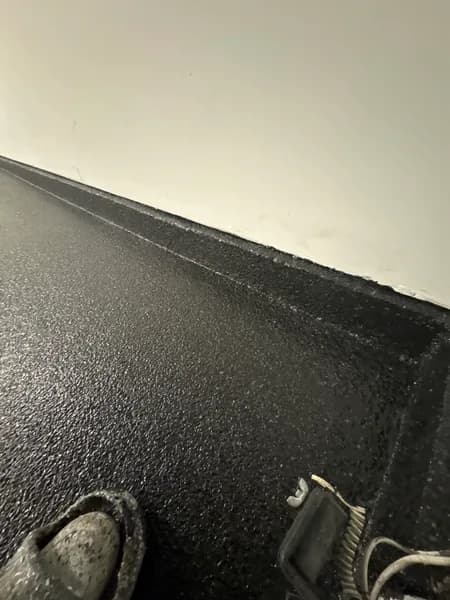 Close-up of a Carbon flake epoxy garage floor meeting the wall in Delta, BC