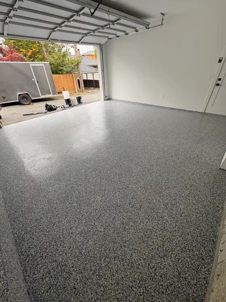 Comet flake epoxy garage floor with the overhead door open in Burnaby, BC