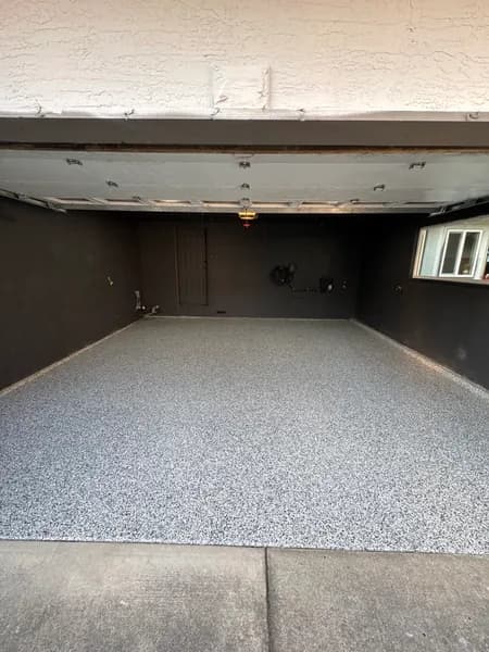 Domino flake epoxy floor in a dark-walled garage in Squamish, BC