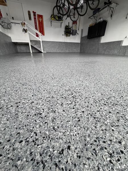 Grey and black flake epoxy garage floor with bikes mounted on the wall