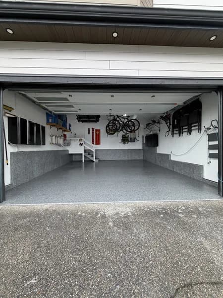 Open two-car garage with grey flake epoxy floor and matching cove base