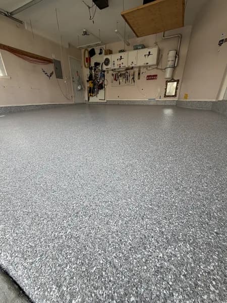 Silver-grey flake epoxy garage floor with tools mounted on the wall