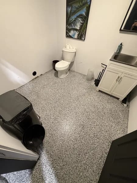 Grey and white flake epoxy floor in a compact commercial washroom