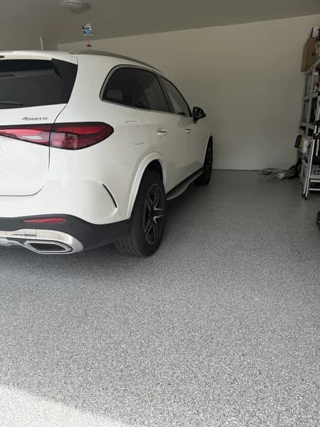 Light grey flake epoxy garage floor with a white SUV parked inside