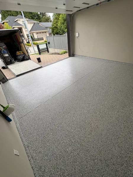 Gravel flake epoxy garage floor with the overhead door open in Richmond, BC