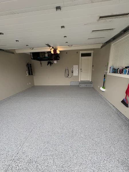 Gravel flake epoxy floor in a two-car garage with wall-mounted TV in Richmond, BC