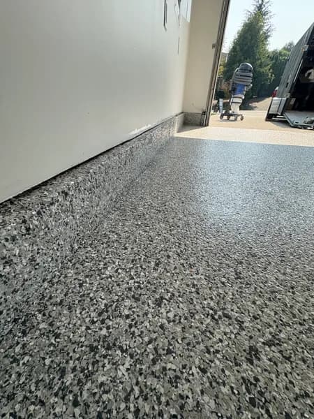 Gravel flake epoxy garage floor and cove base looking out to the driveway in Surrey, BC