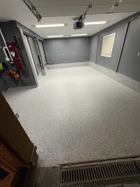 Stoney Creek flake epoxy garage floor beside a trench drain in North Vancouver, BC