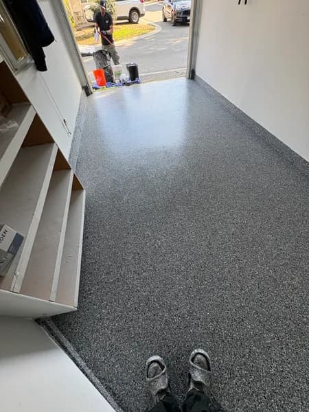 Wombat flake epoxy floor in a one-car garage with built-in shelving in Vancouver, BC