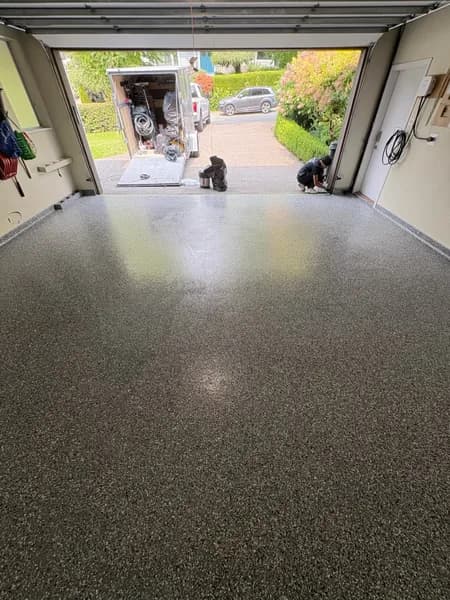 Wombat flake epoxy garage floor with the overhead door open in West Vancouver, BC