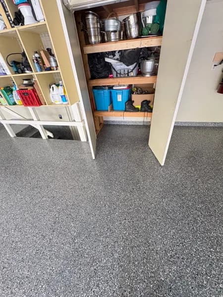 Wombat flake epoxy floor in a garage storage nook with shelving in West Vancouver, BC