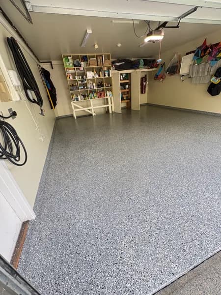 Wombat flake epoxy garage floor with wall-mounted storage in West Vancouver, BC