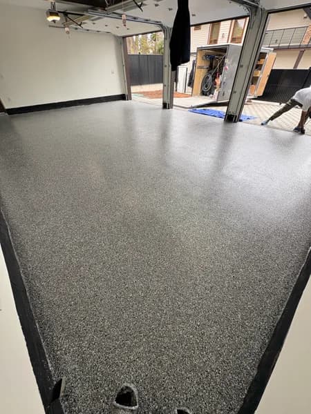 Wombat flake epoxy floor with black cove base in a three-car garage in White Rock, BC