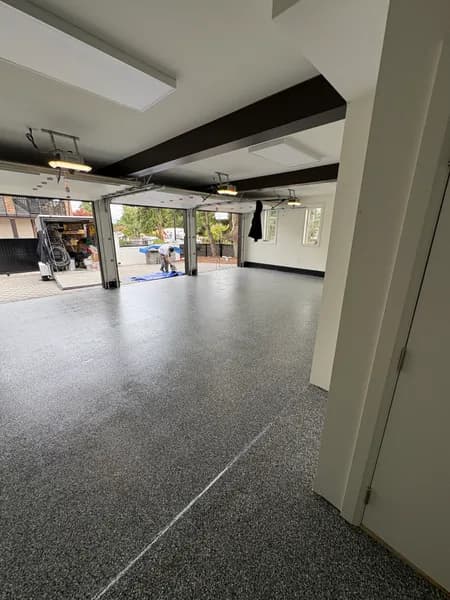 Wombat flake epoxy three-car garage floor with exposed beams in White Rock, BC