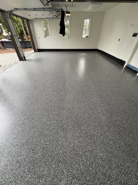 Wide view of a Wombat flake epoxy floor across three garage bays in White Rock, BC