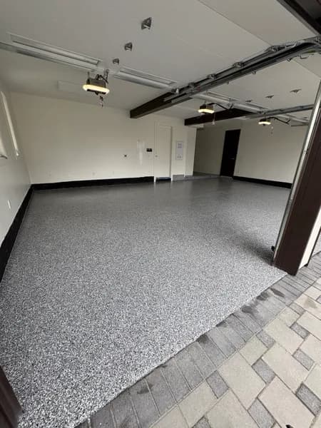 Wombat flake epoxy garage floor with black cove base and white walls in White Rock, BC