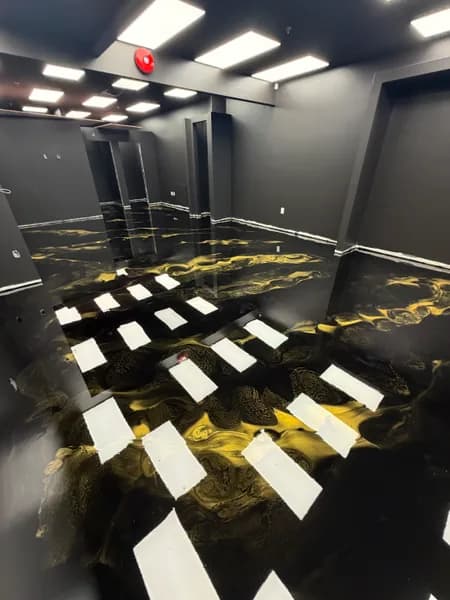 Black and gold metallic epoxy floor reflecting ceiling lights in a downtown Vancouver retail store
