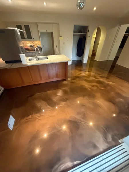 Bronze metallic epoxy basement floor wrapping around a kitchen island in a Vancouver basement suite