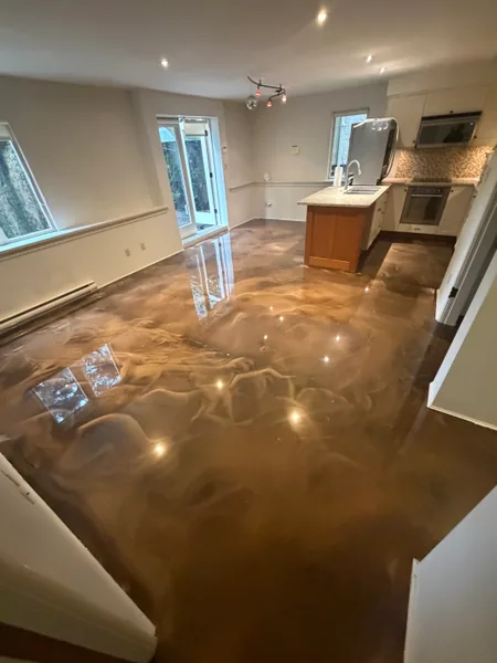 Bronze metallic epoxy floor reflecting windows in an open-plan Vancouver basement suite