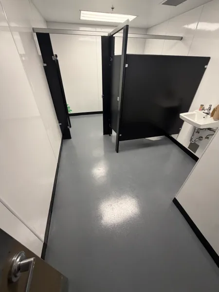 Glossy grey solid epoxy floor in a commercial restroom in Coquitlam, BC